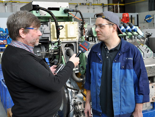 Martin Weidner, genset mechanic at Caterpillar Energy Solutions, talking to SWR 1 reporter Wolfgang Brauer.